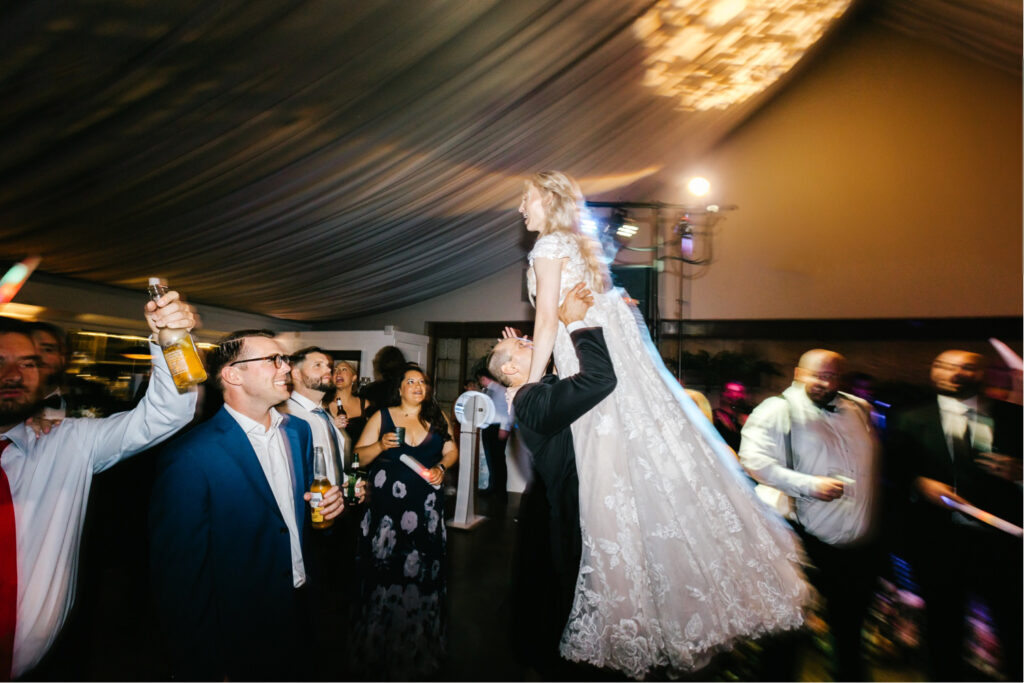 bride and groom doing the "dirty dancing" lift at their summer wedding reception in Philadelphia