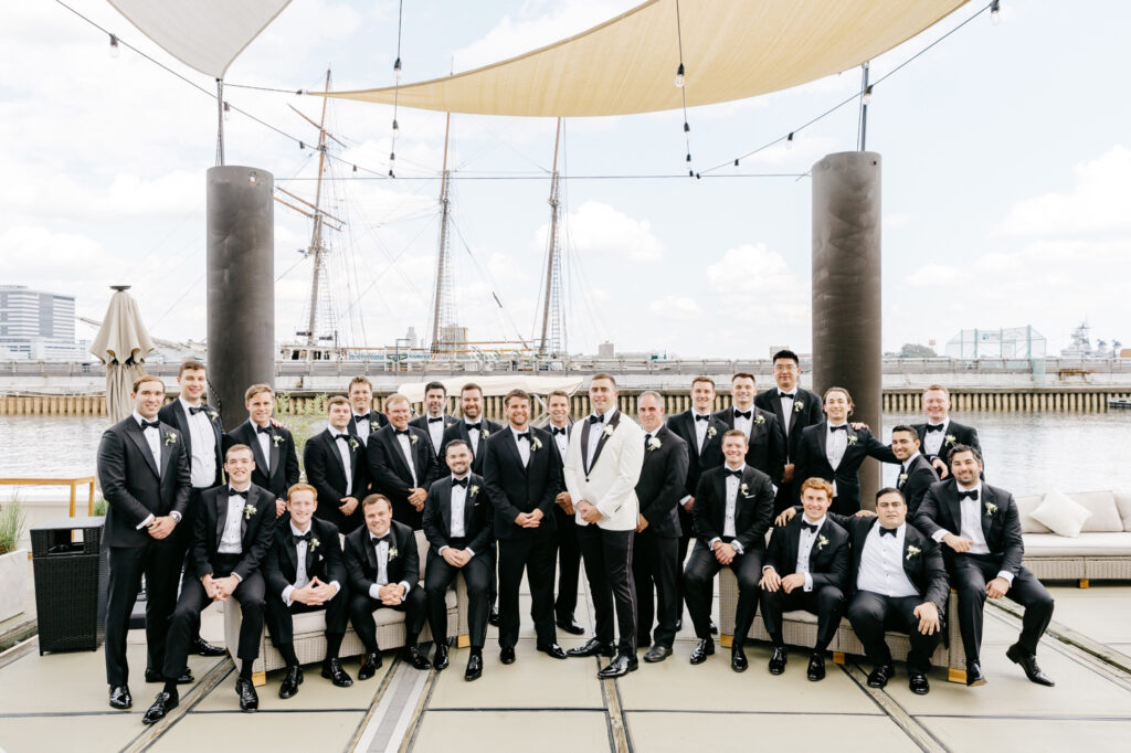 Philadelphia groom with his groomsmen at Penn's Landing on his late spring wedding day