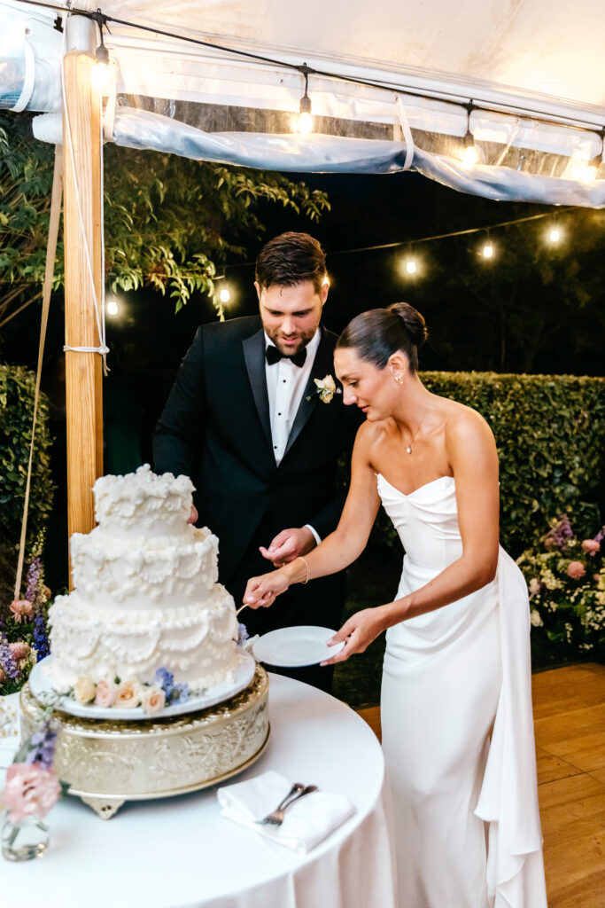 bride and groom cutting their three tier vintage-inspired wedding cake at their summer wedding reception in Cape May, NJ