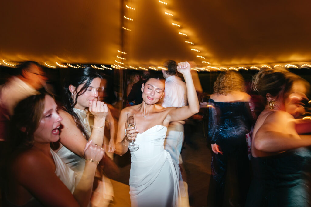 New Jersey bride dancing and having fun during her summer wedding reception under a white tent at Beach Plum Farm