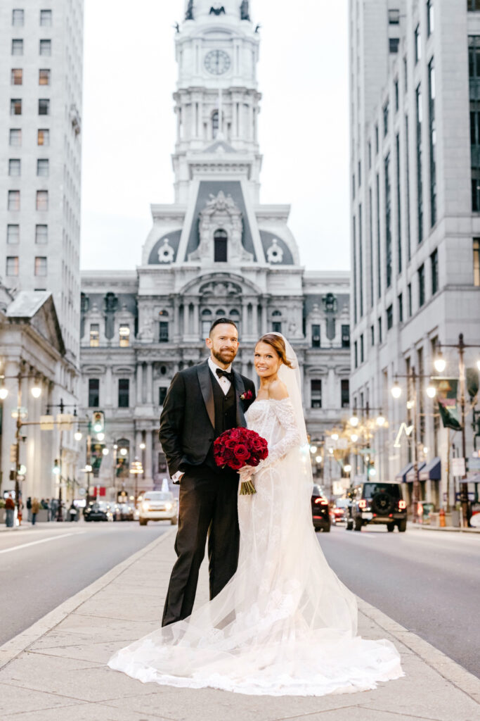 Philadelphia bride and groom on Broad Street in Philadelphia in front of City Hall by Emily Wren Photography