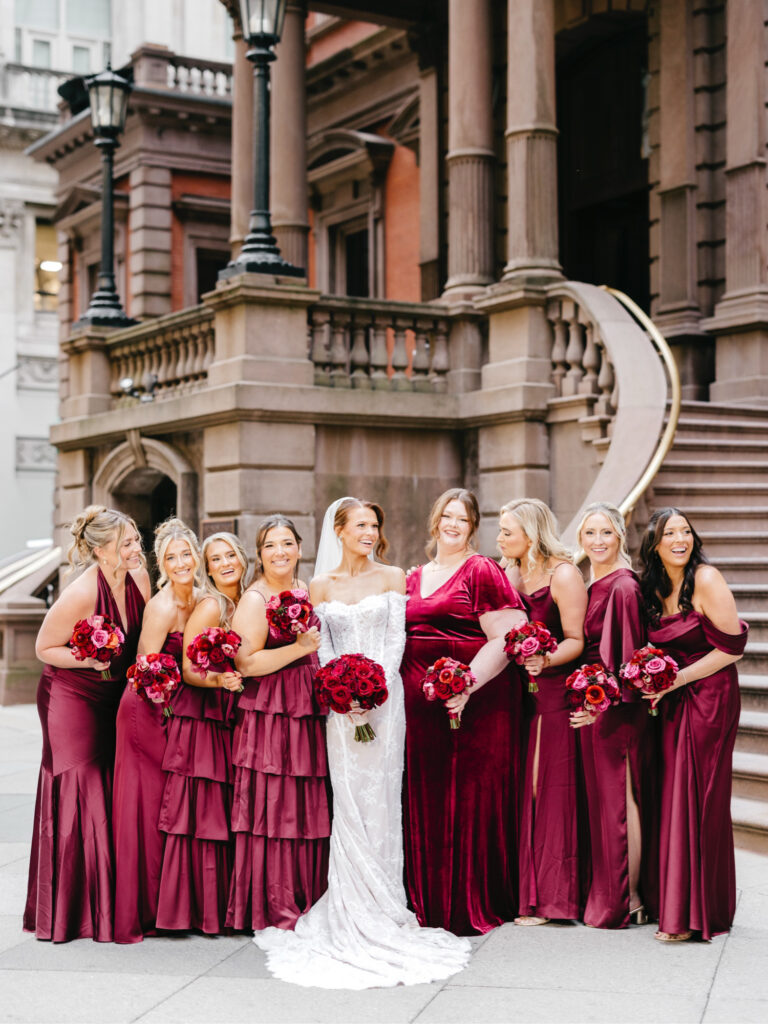 Philadelphia bride with her bridesmaids in velvet red bridesmaid dresses by luxurious wedding photographer Emily Wren Photography