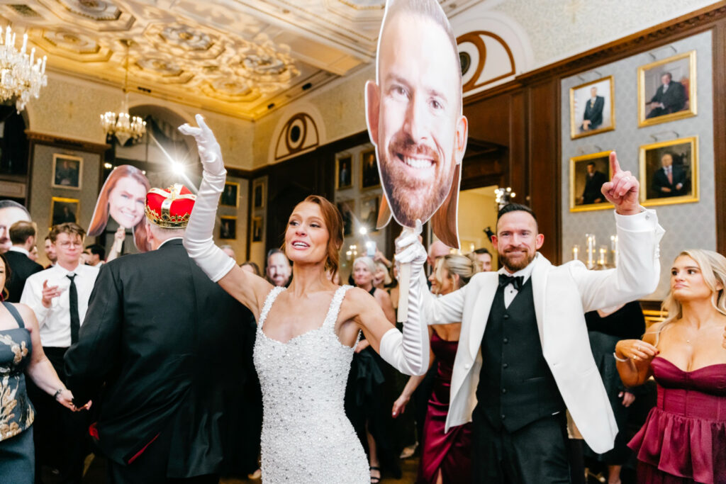 Philadelphia bride and groom with cardboard cut outs of their heads at their fun luxurious wedding reception at the Union League