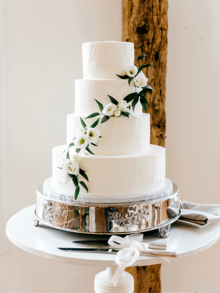 four tier wedding cake with white floral decor by Emily Wren Photography