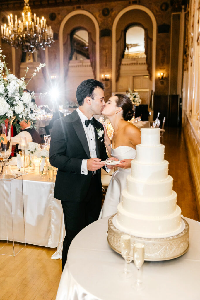 Delaware bride and groom cutting their six tier wedding cake at their Hotel Du Pont wedding reception