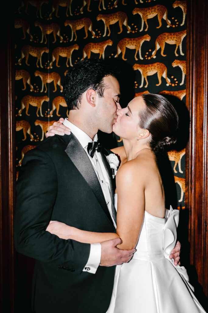 glamorous portrait of bride and groom kissing at the end of their wedding night at Hotel Du Pont