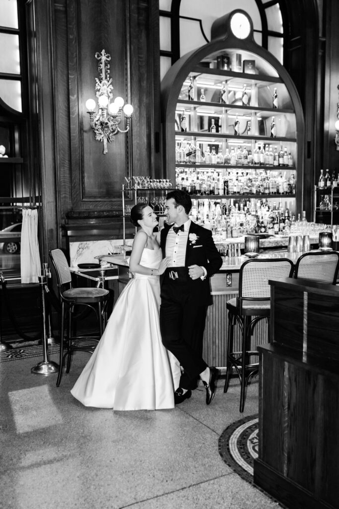 luxurious wedding portrait of the Delaware bride and groom in front of the Hotel du Pont's bar by Emily Wren Photography