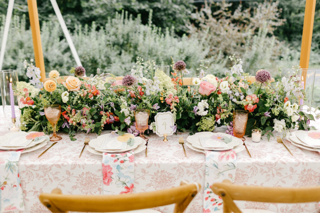 gorgeous summer garden florals aligning a wedding reception table at Uncanoonuc Mountain by Emily Wren Photography