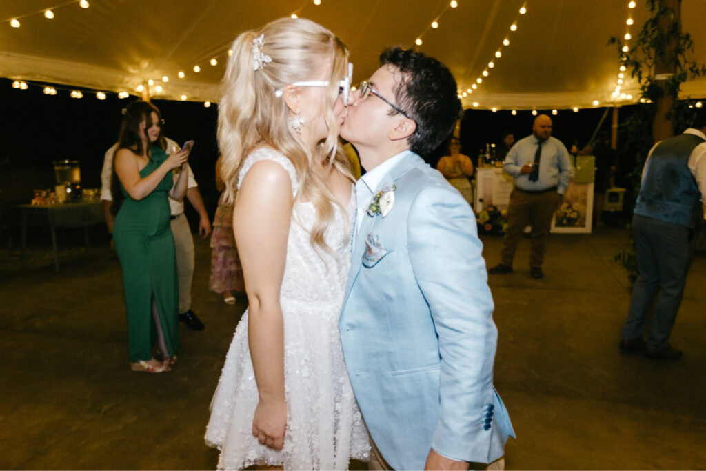 bride and groom kissing at their summer garden wedding reception by New Hampshire wedding photographer Emily Wren Photography