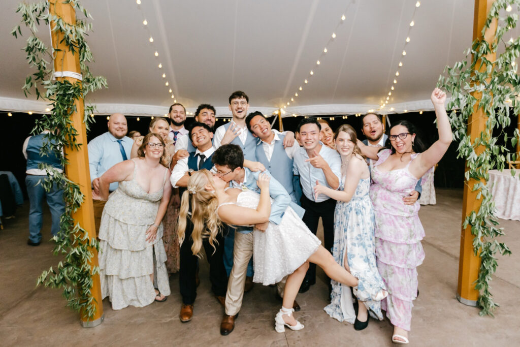 New Hampshire bride and groom kissing at their white-tented summer wedding reception by Emily Wren Photography