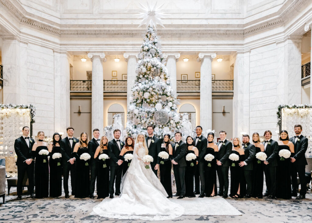 full wedding party portrait in front of the Ritz-Carlton, Philadelphia's Christmas tree on a winter wedding day