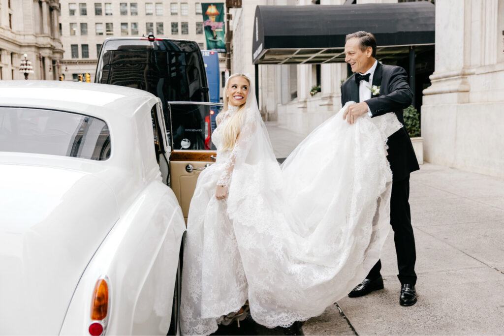 Philadelphia bride getting into a vintage Rolls-Royce on the way to her wedding ceremony in Center City