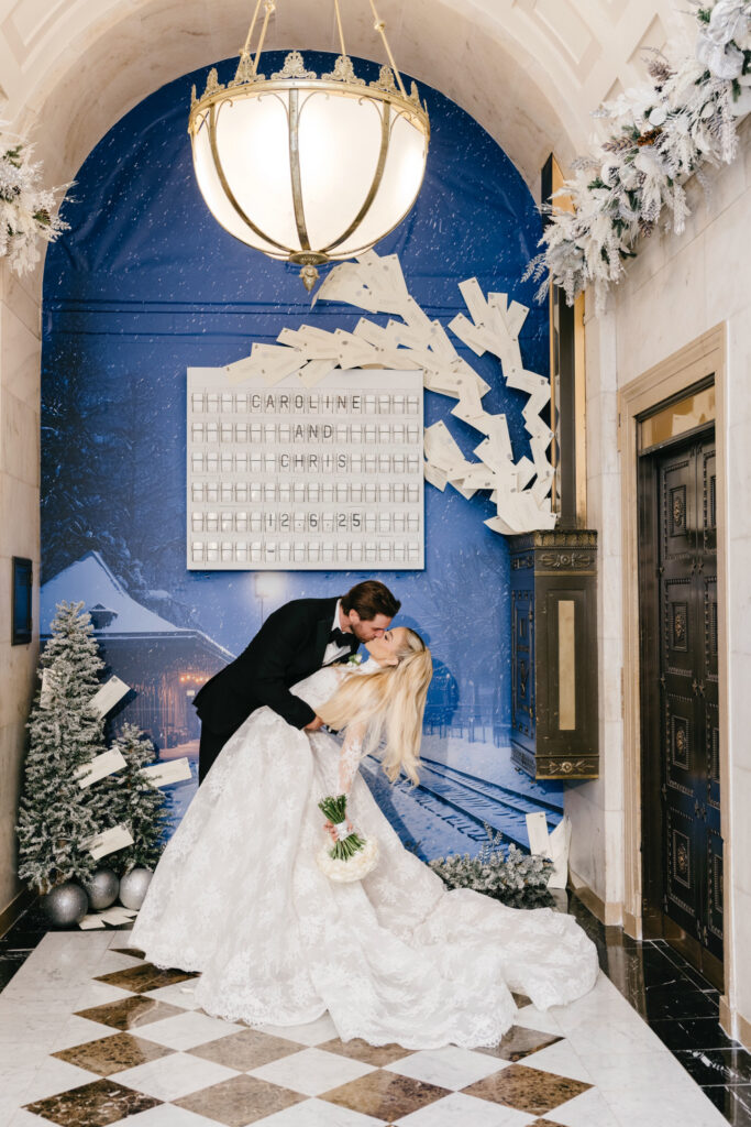 bride and groom kissing in front of a marquee with their names on it at the Ritz-Carlton, Philadelphia