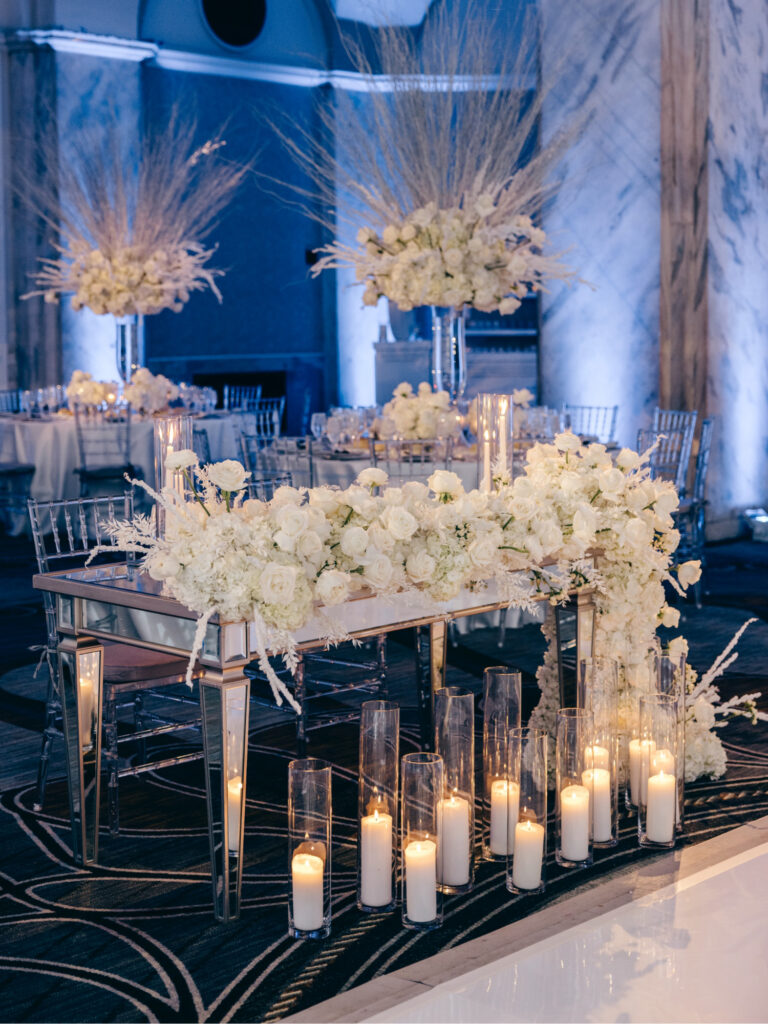 Wedding reception sweetheart table decorated with all white roses and candles at the Ritz-Carlton, Philadelphia