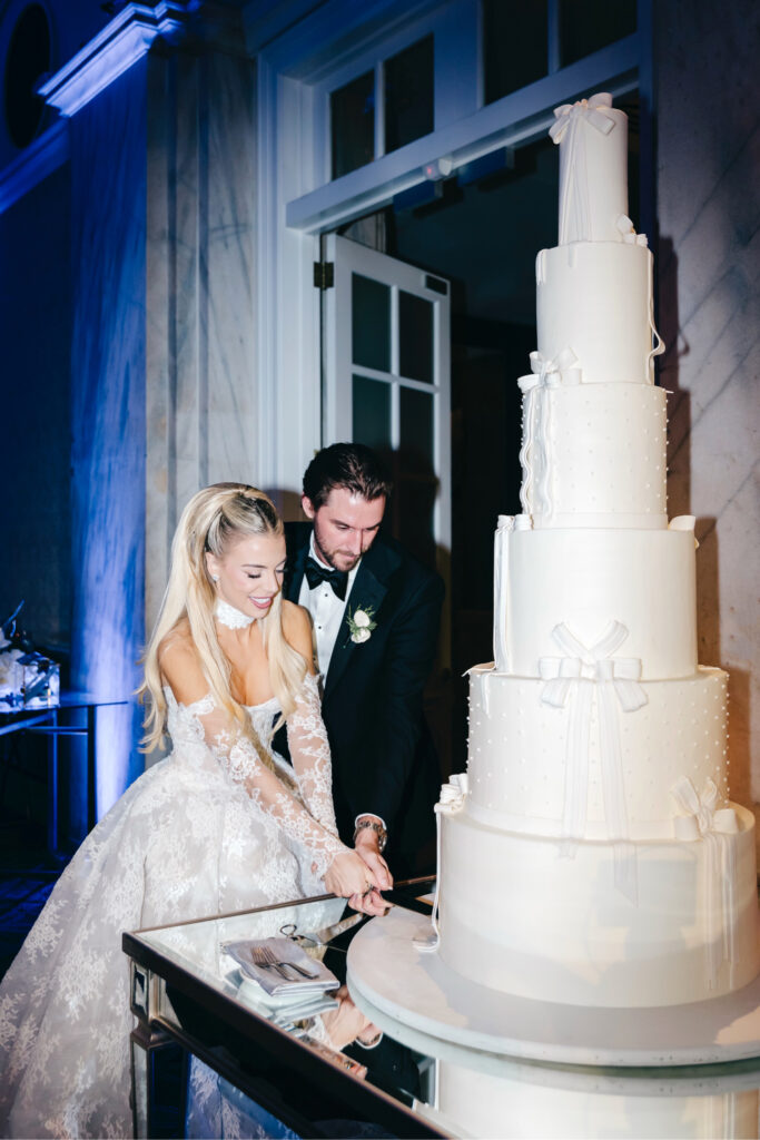 Bride and groom cutting their seven-tier wedding cake at their luxurious winter wedding reception at The Ritz-Carlton, Philadelphia