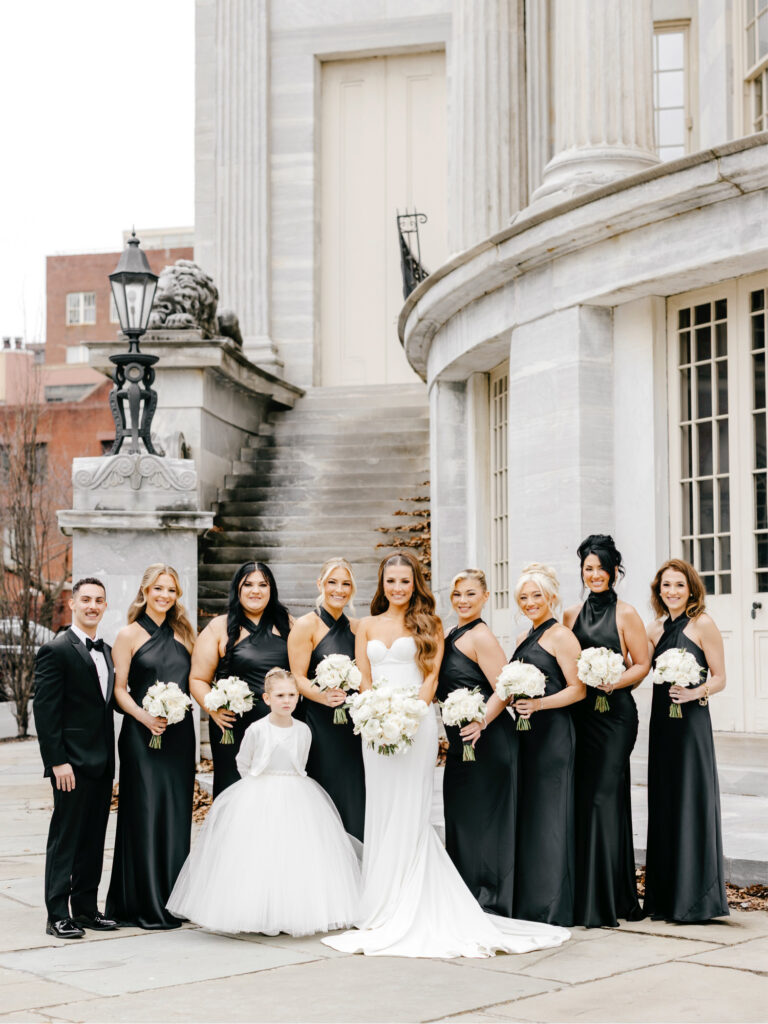 Philadelphia bride with her bridesmaids in matching black bridesmaid dresses on her March wedding day in Center City