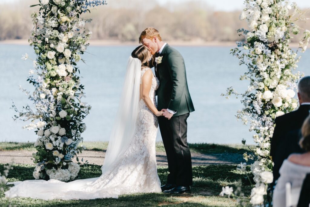 bride and groom's first kiss at their outdoor wedding ceremony along the river at Glen Foerd