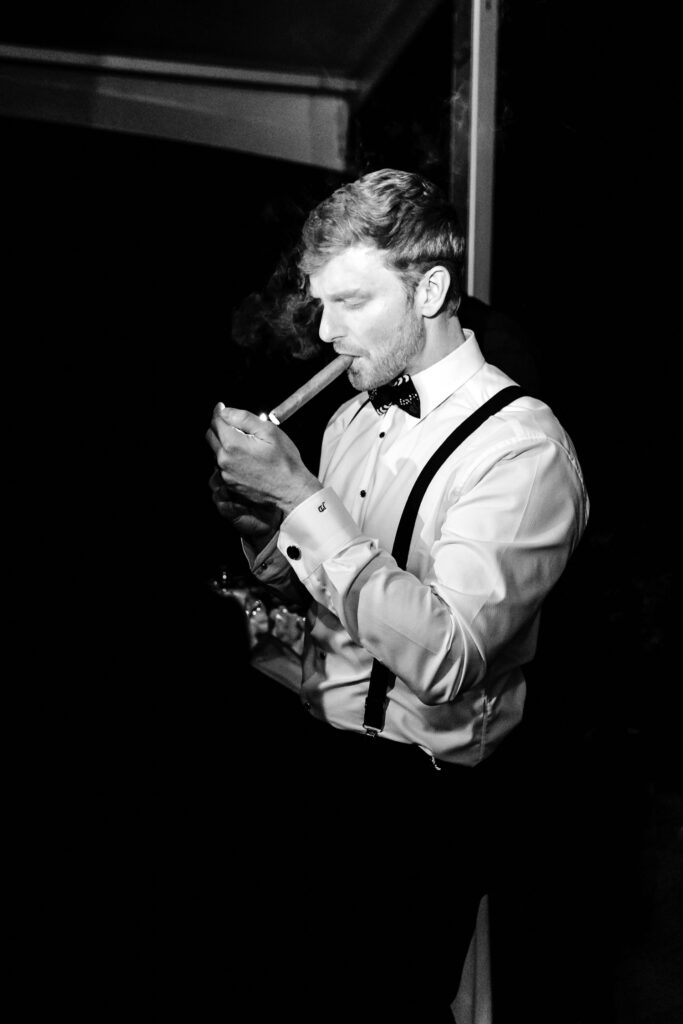 cool portrait of Philadelphia groom smoking a cigar at his wedding reception by Emily Wren Photography
