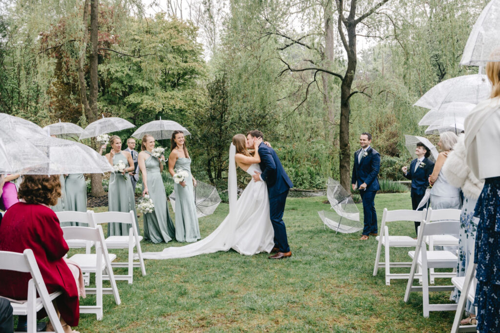 bride and groom's first kiss at their outdoor wedding ceremony at Appleford Estate by Emily Wren Photography