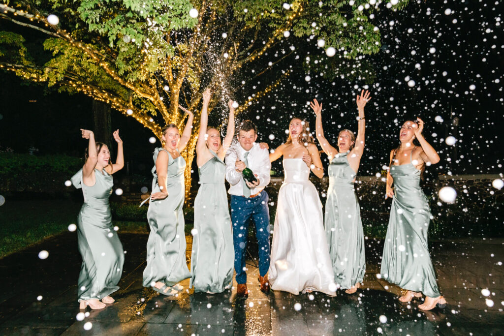champagne pop with bride, groom, and bridesmaids at Philadelphia wedding reception by Emily Wren Photography