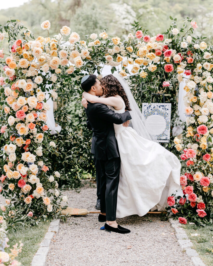 bride and groom's first kiss at their outdoor garden wedding ceremony at River House at Odette's