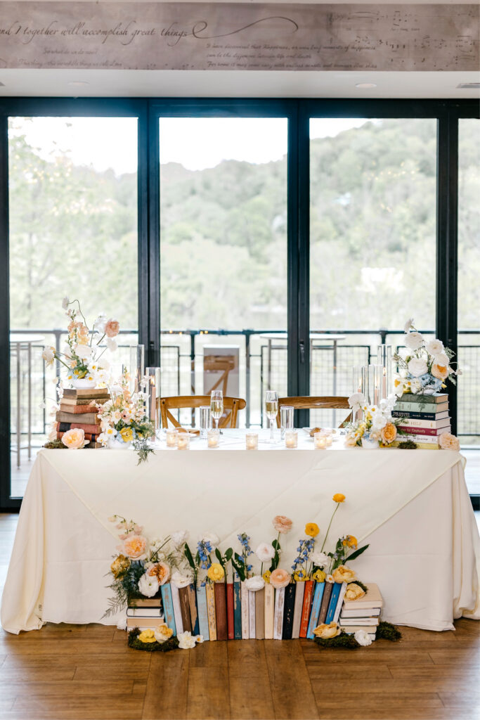 garden and book inspired sweetheart table at whimsical spring wedding reception