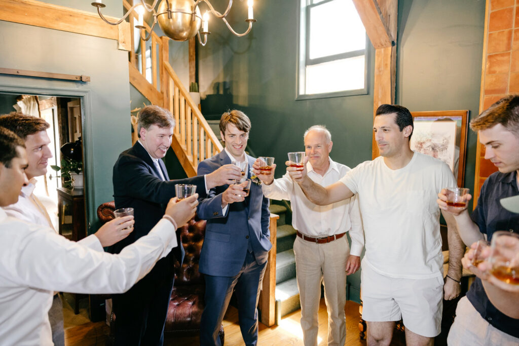 Philadelphia groom taking shots with his groomsmen as he gets ready for his summer wedding day by Emily Wren Photography