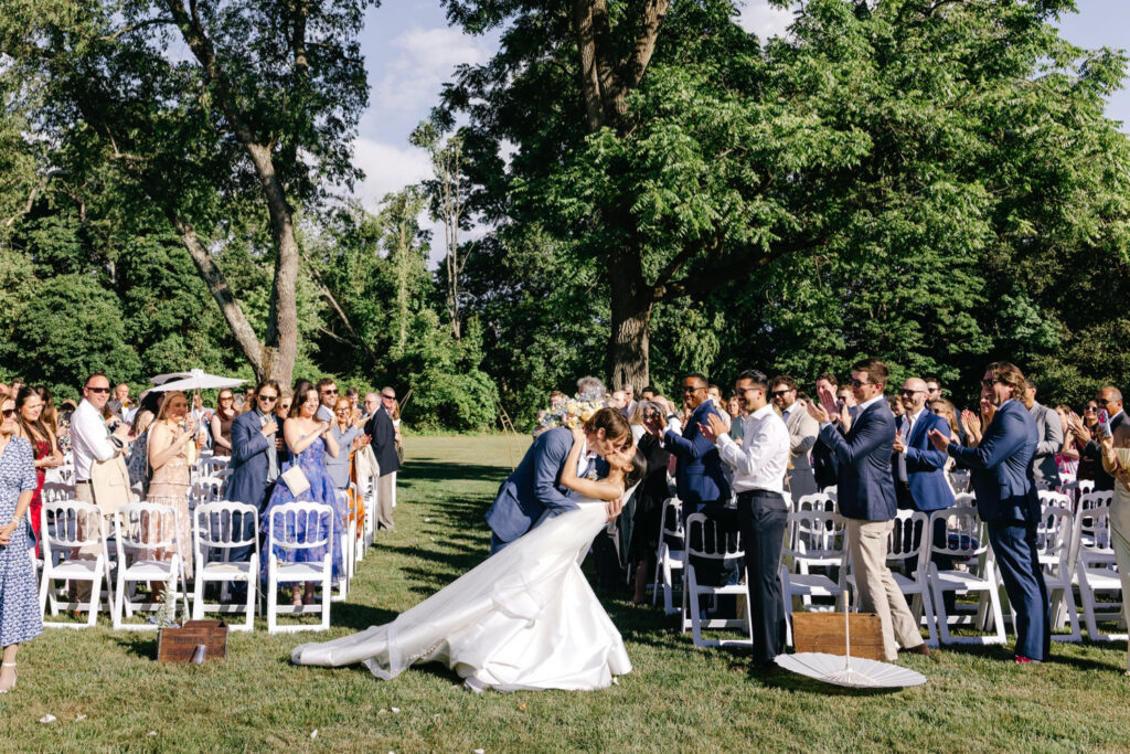 Philadelphia bride and groom kissing as they exit their outdoor summer wedding ceremony in Holicong, Pennsylvania